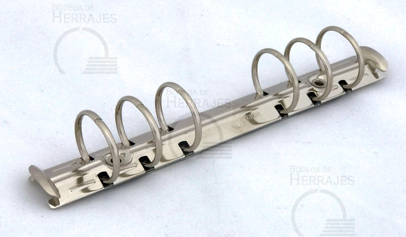 Mecanismo de 1 pulgada con 17.1 cm de largo, listo para instalar, con palancas laterales para abrir. Acabado niquelado (plata) y seis argollas con capacidad para 200 hojas. Base de 20 mm de ancho y separación entre argollas de 19 mm, 19 mm, 51 mm (centro), 19 mm, 19 mm. Ideal para carpetas de bolsillo, agendas, directorios y materiales de encuadernación. Mecanismo de 1 pulgada con 17.1 cm de largo, listo para instalar, con palancas laterales para abrir. Acabado niquelado (plata) y seis argollas con capacidad para 200 hojas. Base de 20 mm de ancho y separación entre argollas de 19 mm, 19 mm, 51 mm (centro), 19 mm, 19 mm. Ideal para carpetas de bolsillo, agendas, directorios y materiales de encuadernación.